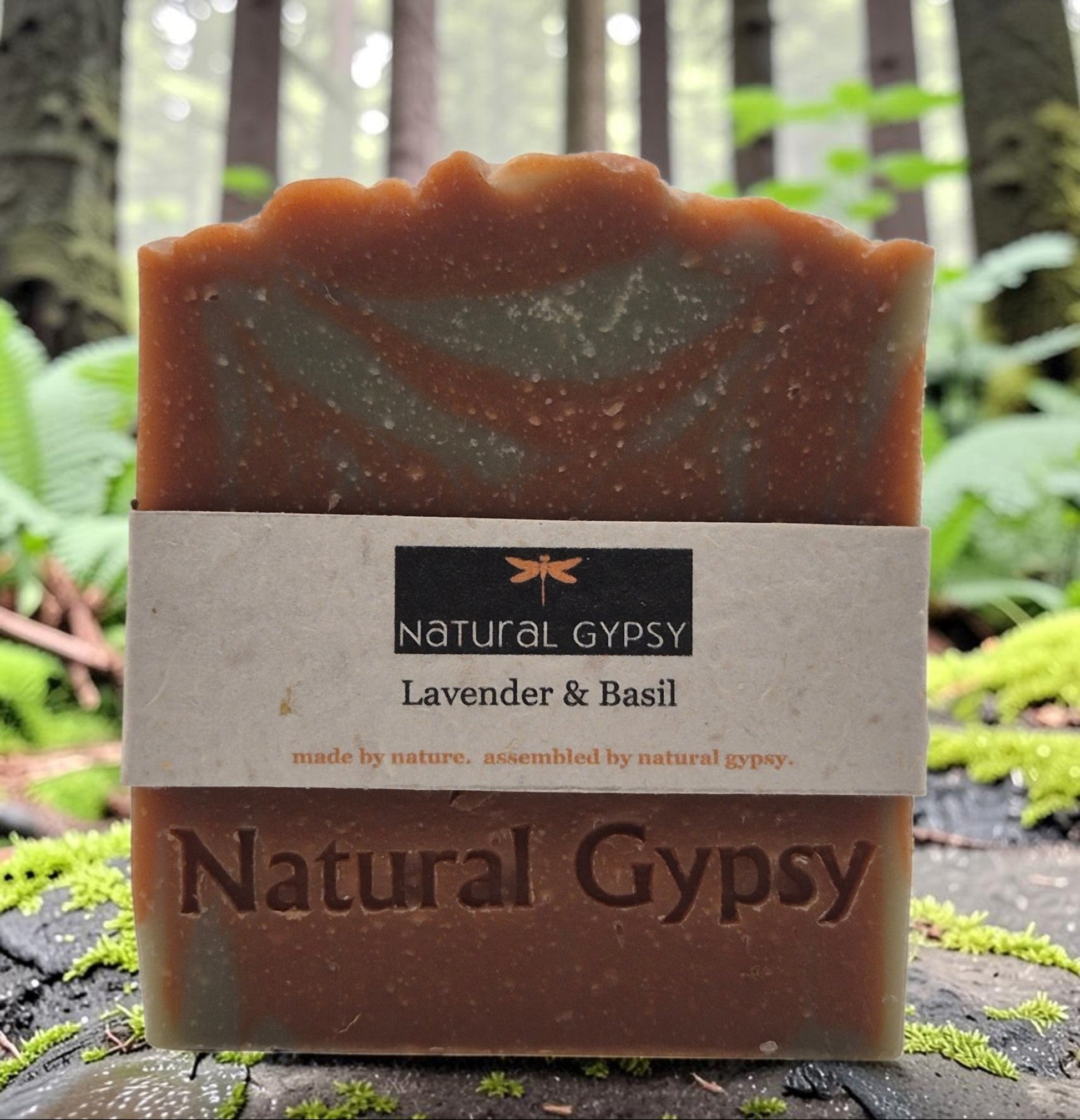 Natural Gypsy handcrafted lavender and basil artisan soap bar with rustic texture, set against a forest background.