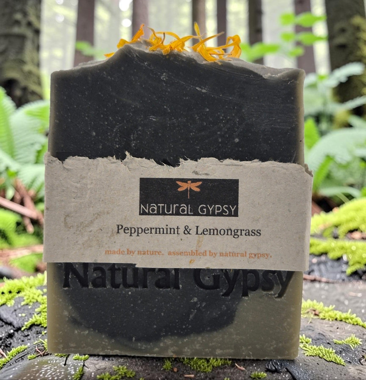Natural Gypsy peppermint and lemongrass artisan soap bar topped with calendula petals in a forest setting